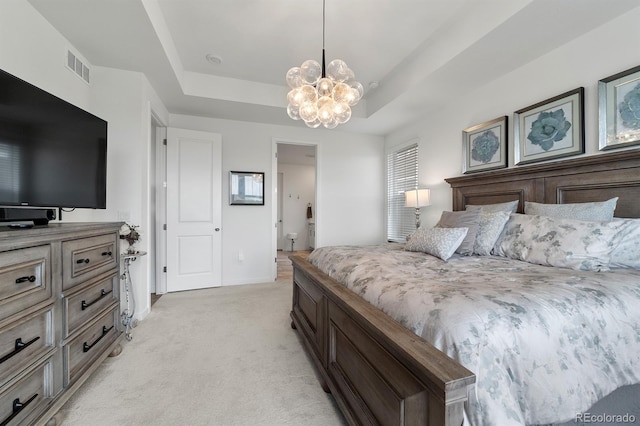 carpeted bedroom with a chandelier and a raised ceiling