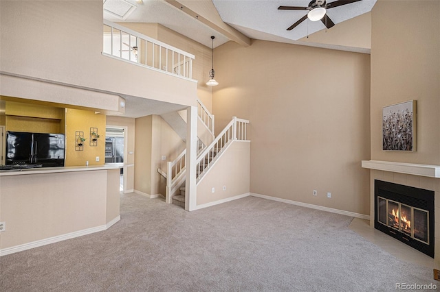 unfurnished living room featuring a fireplace, ceiling fan, light carpet, high vaulted ceiling, and beamed ceiling