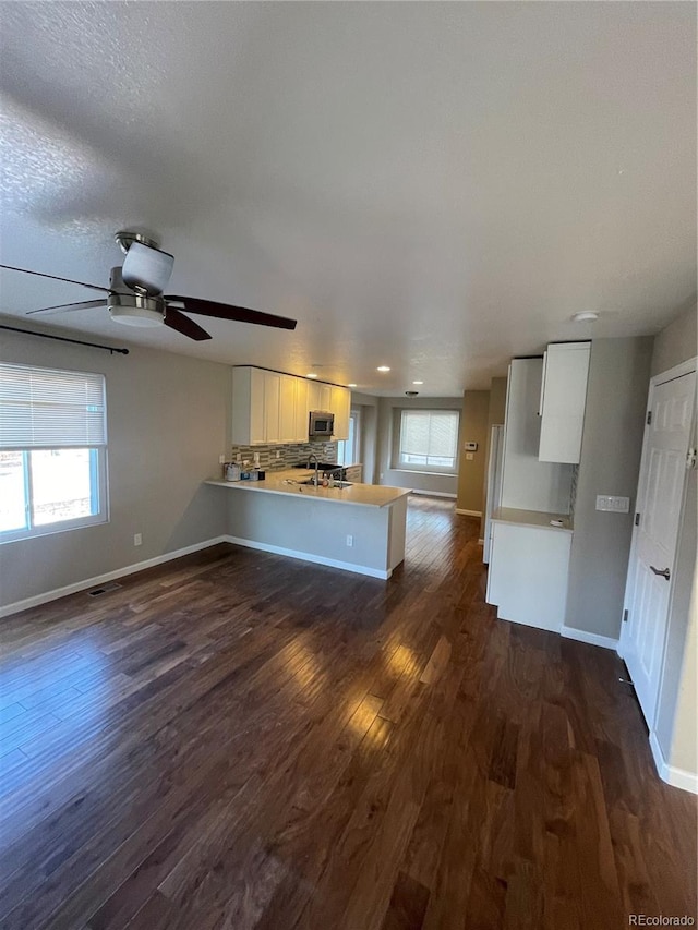 unfurnished living room with plenty of natural light and dark hardwood / wood-style floors