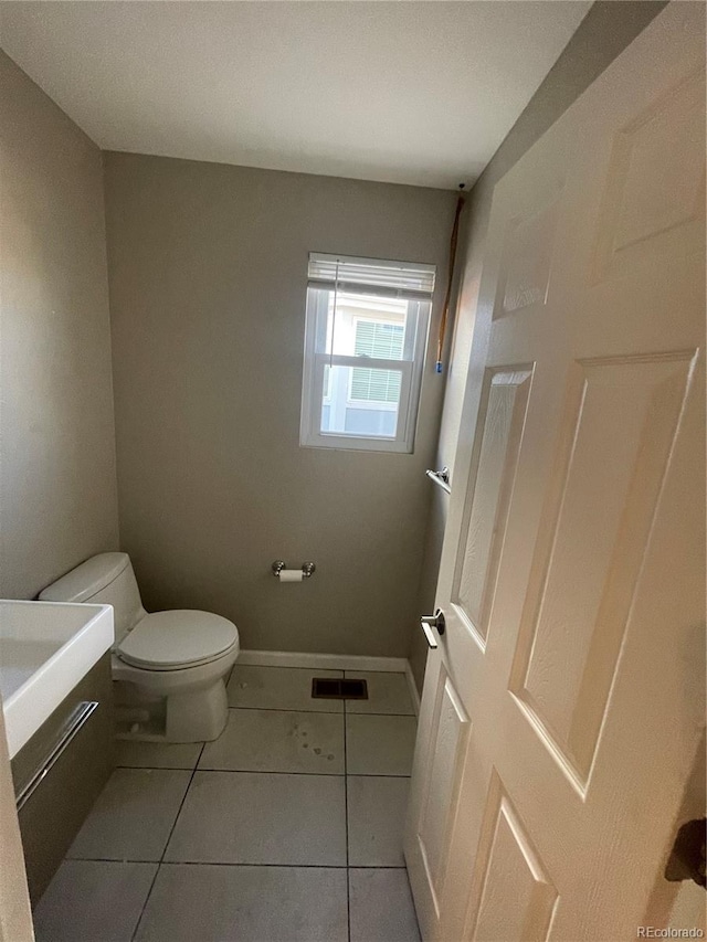 bathroom featuring tile flooring and toilet