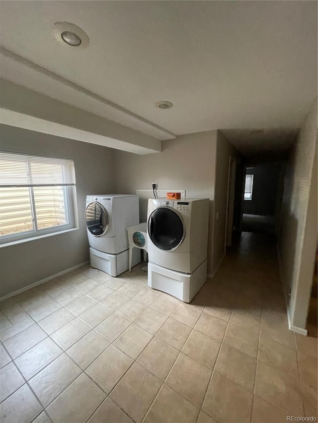 washroom with washer and dryer and light tile floors