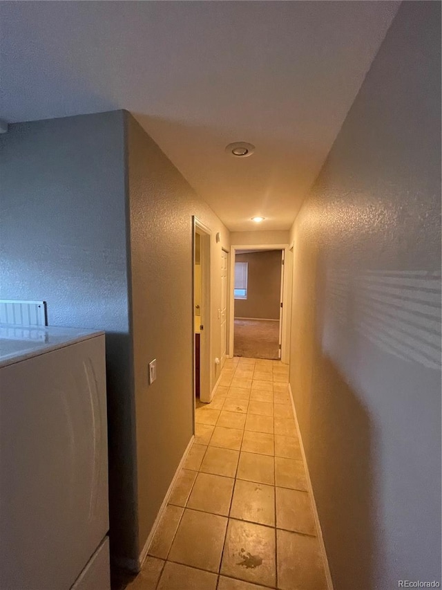 hallway featuring light tile flooring and washer / clothes dryer