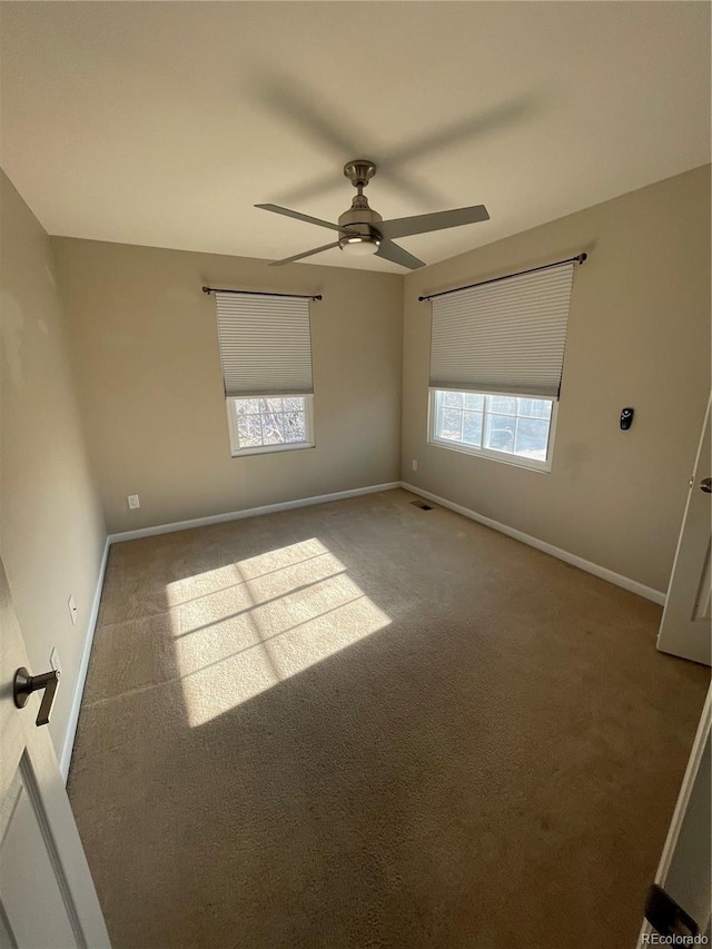 spare room with light colored carpet and ceiling fan