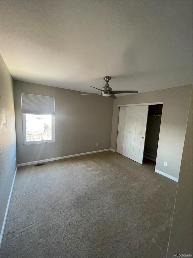 unfurnished bedroom featuring a closet, ceiling fan, and dark colored carpet