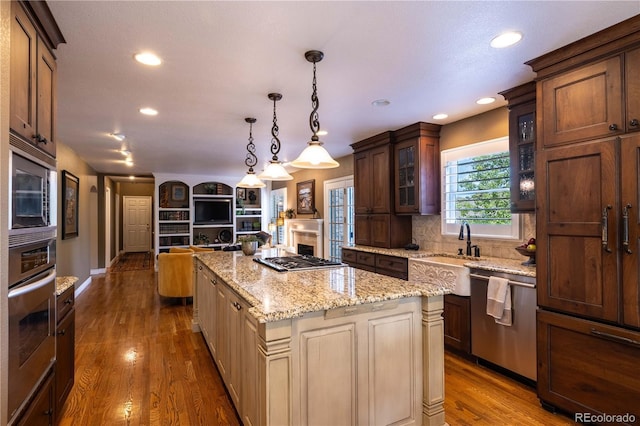 9 Roder Gate Ln, Castle Pines, CO 80108 - kitchen with stainless steel appliances, a sink, recessed lighting, glass insert cabinets, and dark wood-style floors