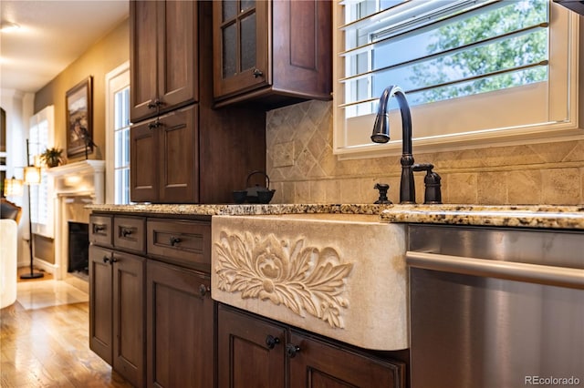 9 Roder Gate Ln, Castle Pines, CO 80108 - kitchen with dishwasher, decorative backsplash, light stone counters, and glass insert cabinets