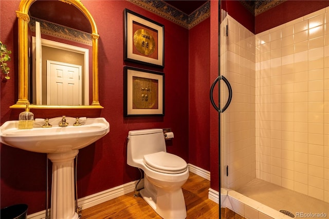 9 Roder Gate Ln, Castle Pines, CO 80108 - bathroom featuring wood finished floors, tiled shower, toilet, and baseboards