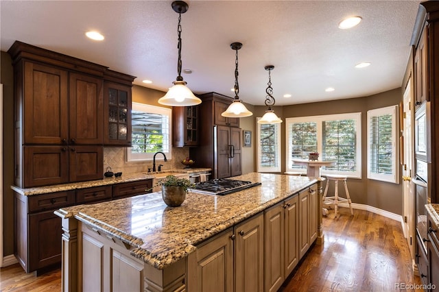 9 Roder Gate Ln, Castle Pines, CO 80108 - kitchen featuring baseboards, recessed lighting, glass insert cabinets, a sink, and built in appliances