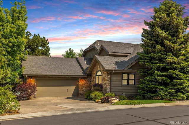 9 Roder Gate Ln, Castle Pines, CO 80108 - view of front of house with stone siding, a garage, driveway, and roof with shingles