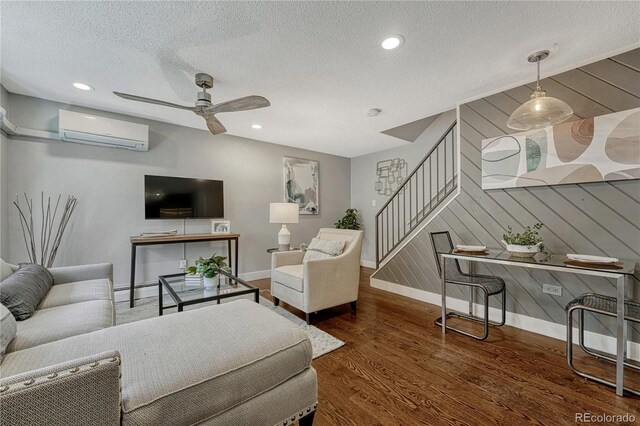 1355 Gaylord St Unit 6, Denver, CO 80206 - living area with a wall mounted air conditioner, baseboards, stairs, wood finished floors, and a textured ceiling