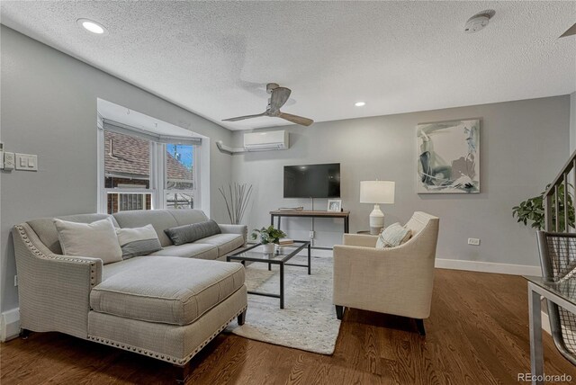 1355 Gaylord St Unit 6, Denver, CO 80206 - living area featuring an AC wall unit, a textured ceiling, a ceiling fan, baseboards, and wood finished floors