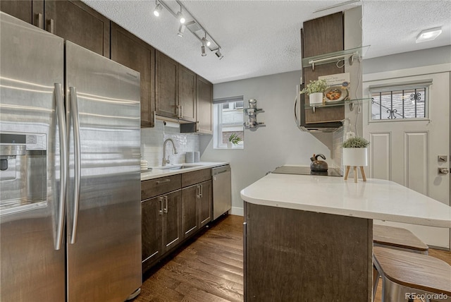 1355 Gaylord St Unit 6, Denver, CO 80206 - kitchen with stainless steel appliances, a sink, dark brown cabinets, a breakfast bar area, and a textured ceiling
