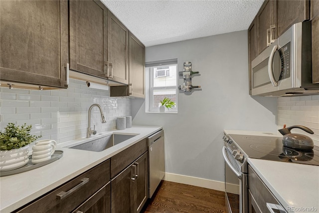 1355 Gaylord St Unit 6, Denver, CO 80206 - kitchen with stainless steel appliances, a sink, light countertops, dark brown cabinets, and dark wood-style floors