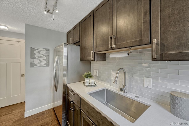 1355 Gaylord St Unit 6, Denver, CO 80206 - kitchen featuring a sink, dark brown cabinetry, dark wood finished floors, a textured ceiling, and tasteful backsplash
