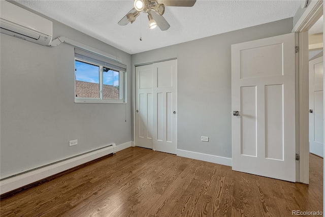 1355 Gaylord St Unit 6, Denver, CO 80206 - unfurnished bedroom with a wall unit AC, a baseboard heating unit, wood finished floors, a textured ceiling, and baseboards