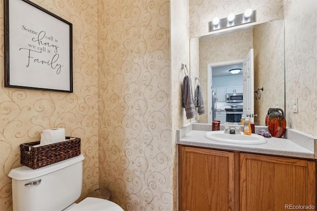 178 Blue Bonnet Dr, Brighton, CO 80601 - bathroom featuring wallpapered walls, toilet, and vanity