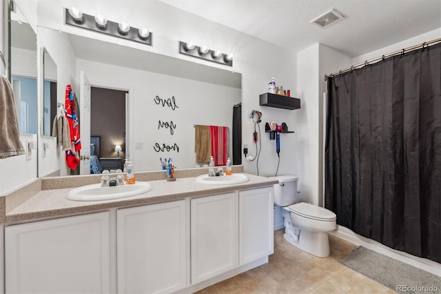 178 Blue Bonnet Dr, Brighton, CO 80601 - ensuite bathroom featuring double vanity, toilet, and tile patterned floors