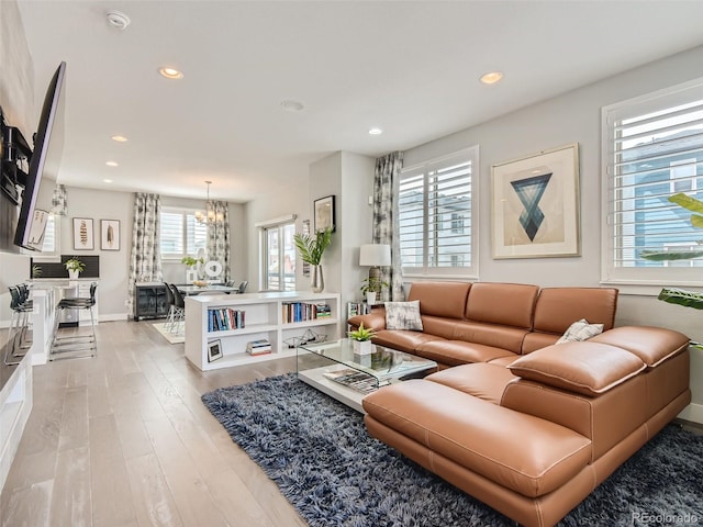 living room featuring light hardwood / wood-style flooring and an inviting chandelier