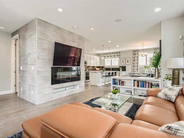 living room featuring a notable chandelier and light hardwood / wood-style flooring