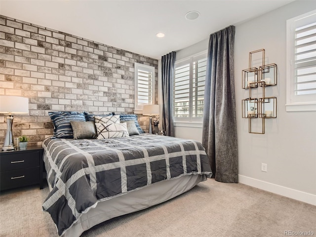 carpeted bedroom featuring brick wall