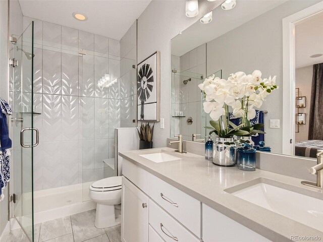 bathroom featuring a shower with door, vanity, and toilet