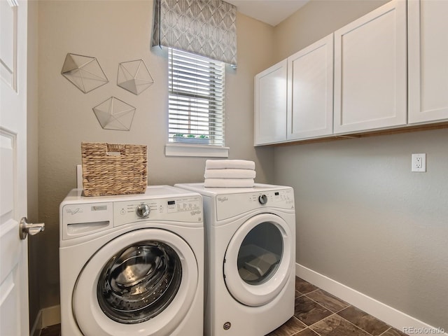 washroom with washing machine and dryer, cabinets, and dark tile patterned flooring