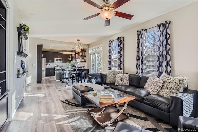 living area featuring light wood-style floors and a ceiling fan