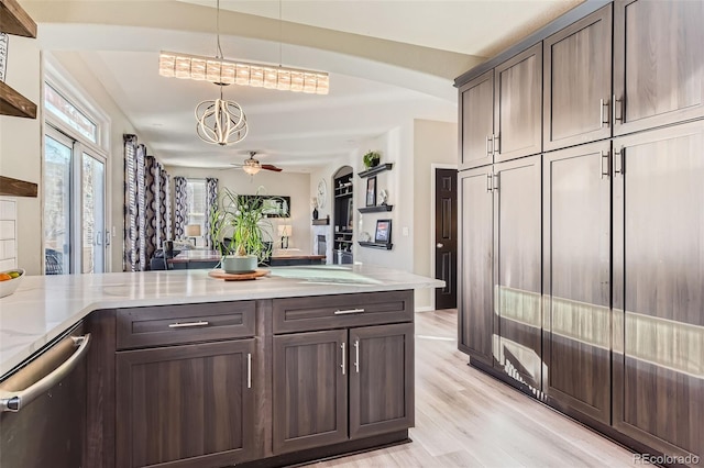 kitchen with hanging light fixtures, light wood-style floors, dark brown cabinetry, light stone countertops, and dishwasher