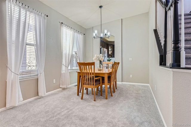 dining area with a chandelier, carpet, stairway, and baseboards