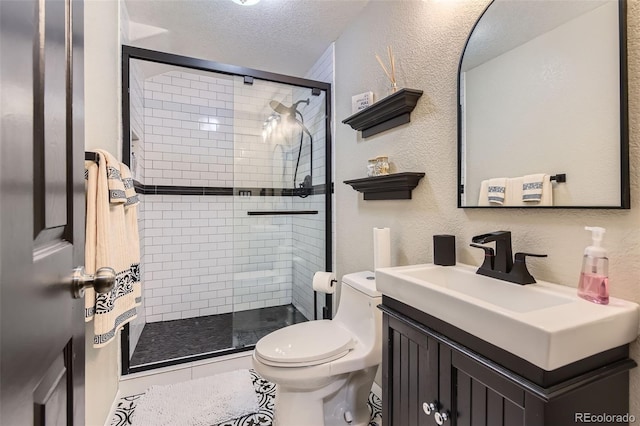 bathroom with a textured wall, toilet, a textured ceiling, vanity, and a shower stall