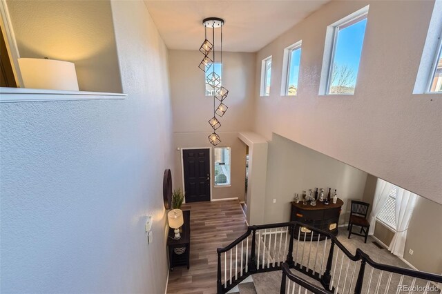 foyer with stairway, a high ceiling, baseboards, and wood finished floors