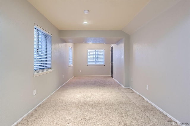 unfurnished room with carpet and baseboards