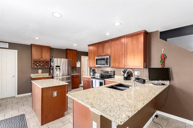 3505 Dinosaur St, Castle Rock, CO 80109 - kitchen featuring appliances with stainless steel finishes, a peninsula, a kitchen island, recessed lighting, and light stone countertops