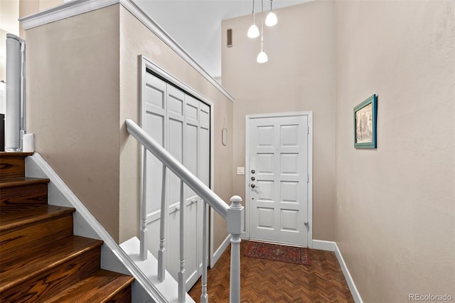 foyer with parquet flooring and a towering ceiling