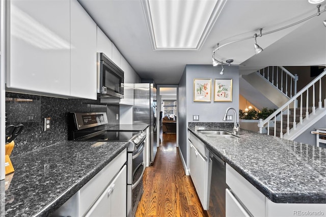 kitchen featuring stainless steel appliances, decorative backsplash, white cabinets, and sink