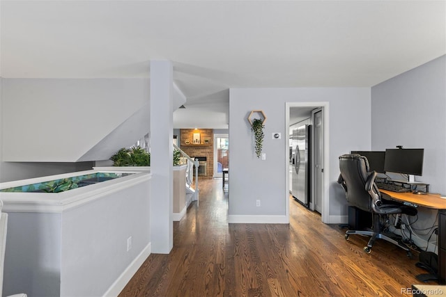 office space with a brick fireplace and dark hardwood / wood-style flooring