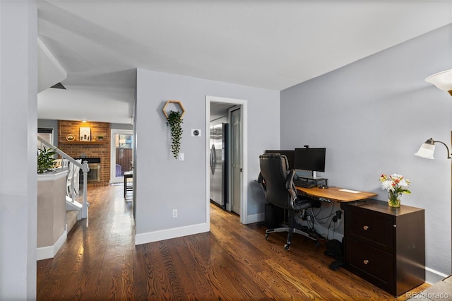 office area featuring dark wood-type flooring and a fireplace