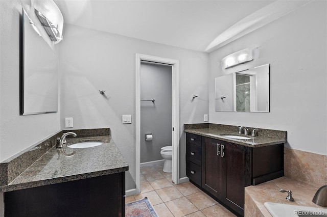 bathroom with toilet, vanity, tile patterned flooring, and a tub to relax in