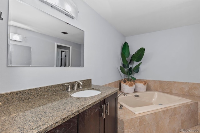 bathroom with tiled tub and vanity