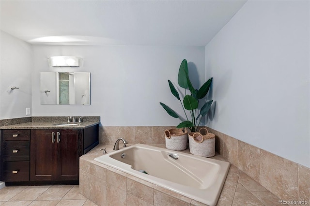 bathroom featuring tiled tub, vanity, and tile patterned flooring