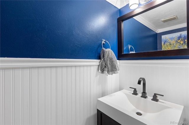 bathroom with ornamental molding and vanity