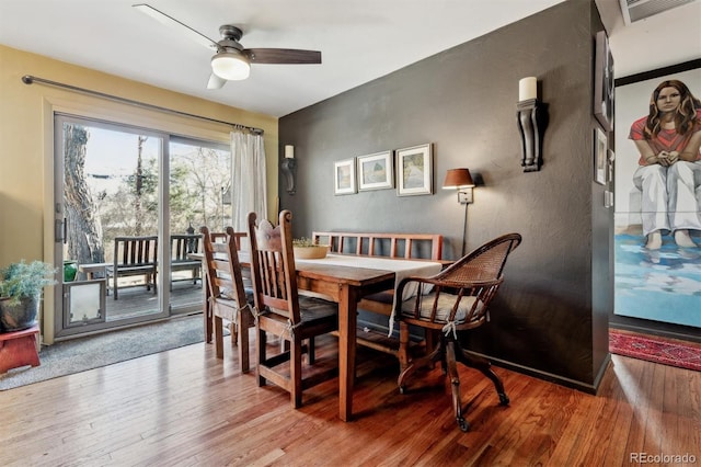 dining space with hardwood / wood-style floors and ceiling fan