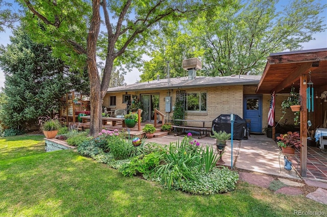 back of property featuring a wooden deck, a yard, and a patio area