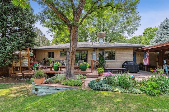 back of house featuring a lawn, a patio, and a deck