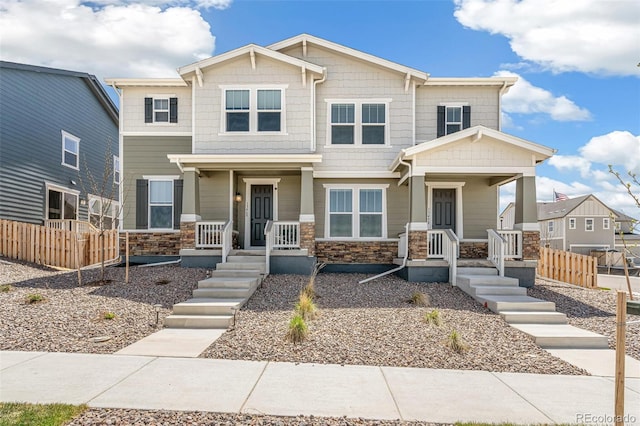 13458 E 111th Ave, Commerce City, CO 80022 - view of front of house featuring covered porch, stone siding, and fence