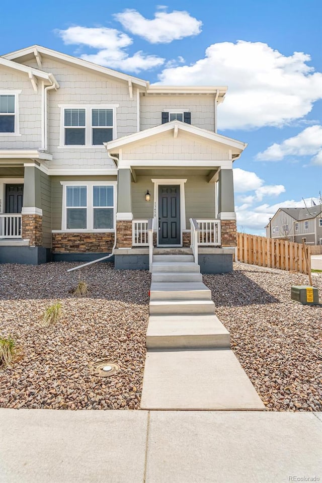 13458 E 111th Ave, Commerce City, CO 80022 - view of front of property featuring stone siding, a porch, and fence
