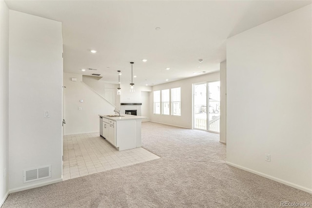 13458 E 111th Ave, Commerce City, CO 80022 - kitchen featuring open floor plan, light colored carpet, baseboards, recessed lighting, and a glass covered fireplace