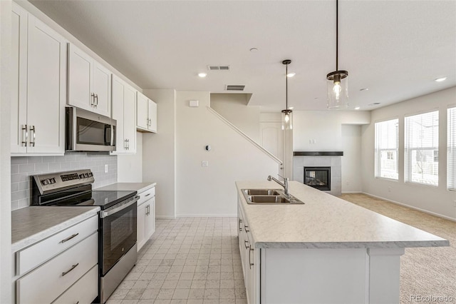 13458 E 111th Ave, Commerce City, CO 80022 - kitchen with appliances with stainless steel finishes, a sink, baseboards, light countertops, and a fireplace