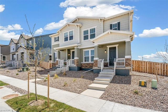 13458 E 111th Ave, Commerce City, CO 80022 - view of front of house with fence, a porch, stone siding, and central AC