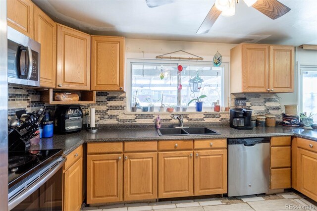 9486 Pelon Dr, Denver, CO 80260 - kitchen featuring appliances with stainless steel finishes, a sink, dark countertops, decorative backsplash, and ceiling fan